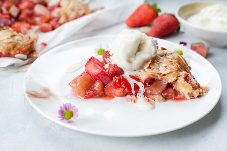 A piece of strawberry rhubarb galette on a white plate.