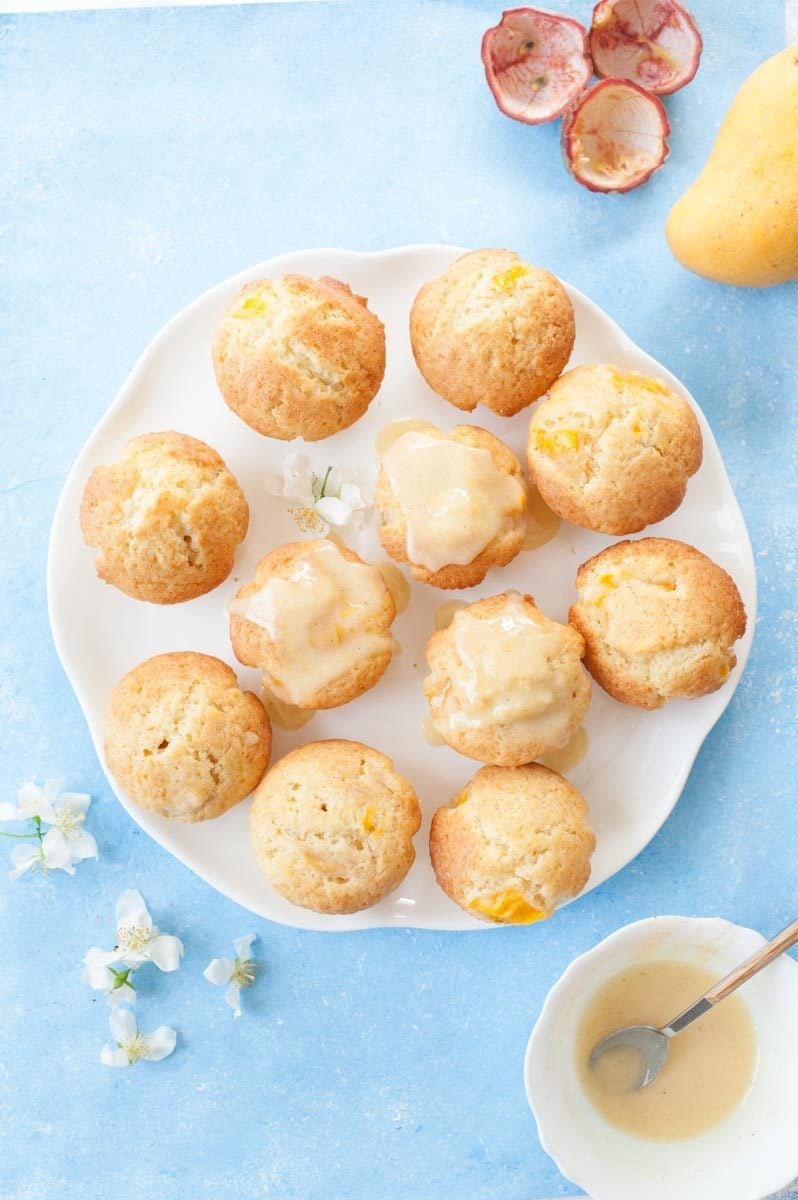 mango muffins with passion fruit glaze on a white plate (overhead shot)