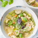 Soupe au pistou in a blue bowl garnished with basil leaves.