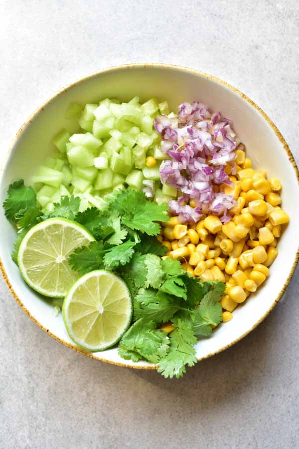 Cucumber corn salsa ingredients in a bowl.