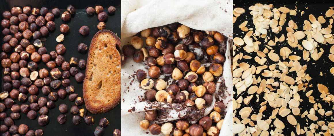 roasted hazelnuts and almonds on a black sheet pan