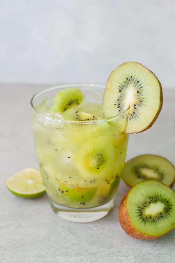 A short glass with kiwi caipirinha.
