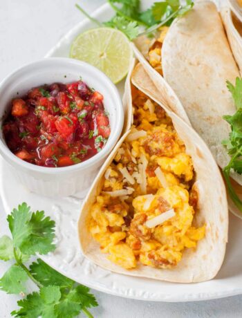 Scrambled eggs tacos with pico de gallo salsa on a plate.