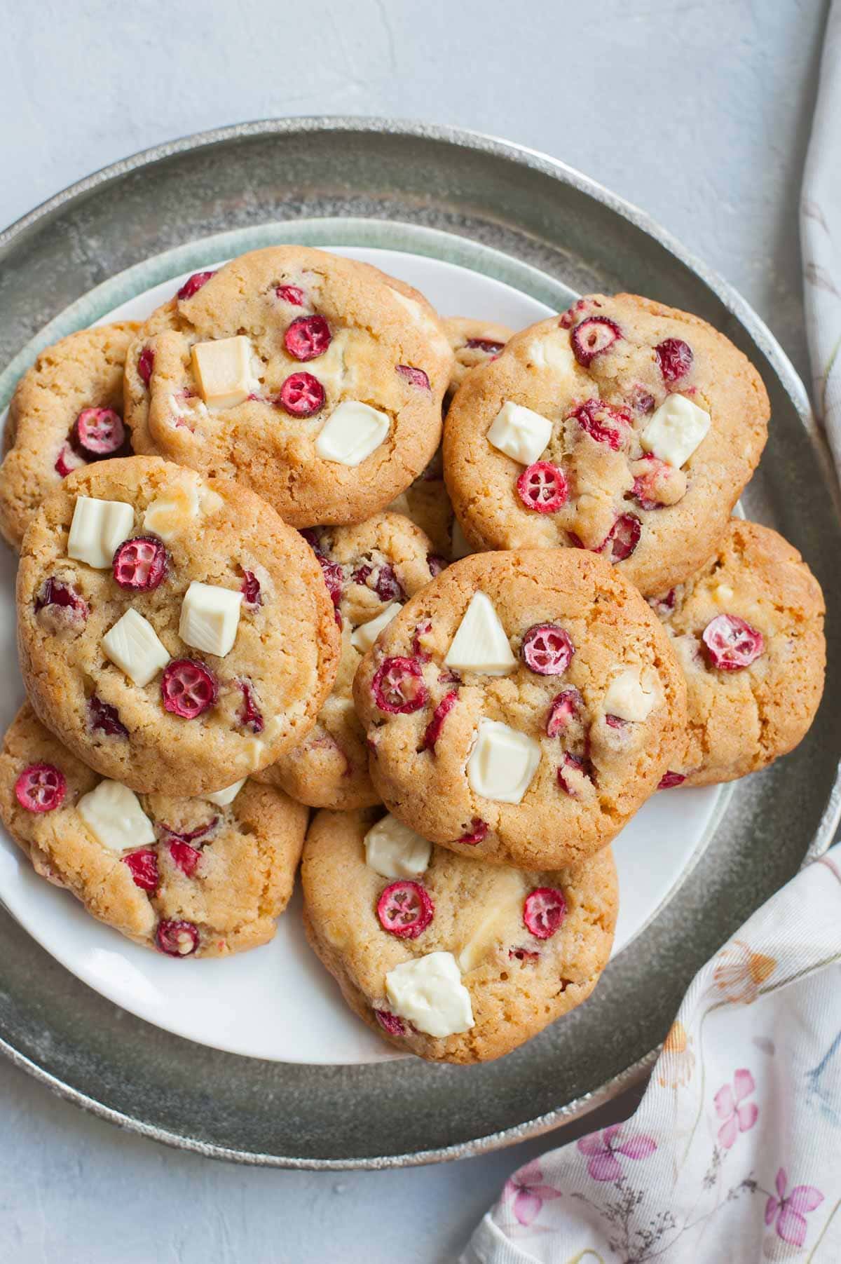 Fresh cranberry white chocolate cookies on a silver tray.