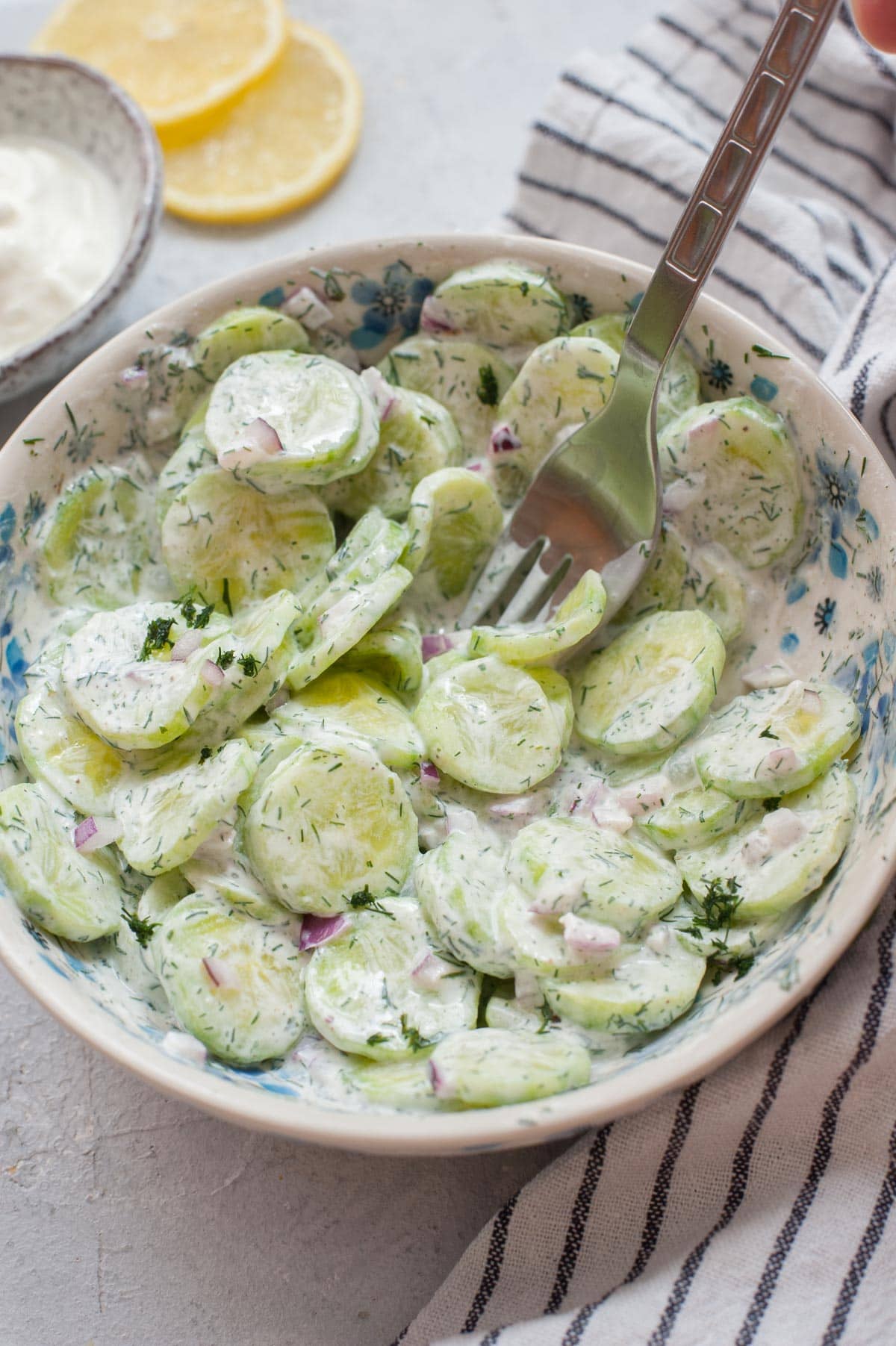 Mizeria (Polish cucumber salad) in a white bowl.