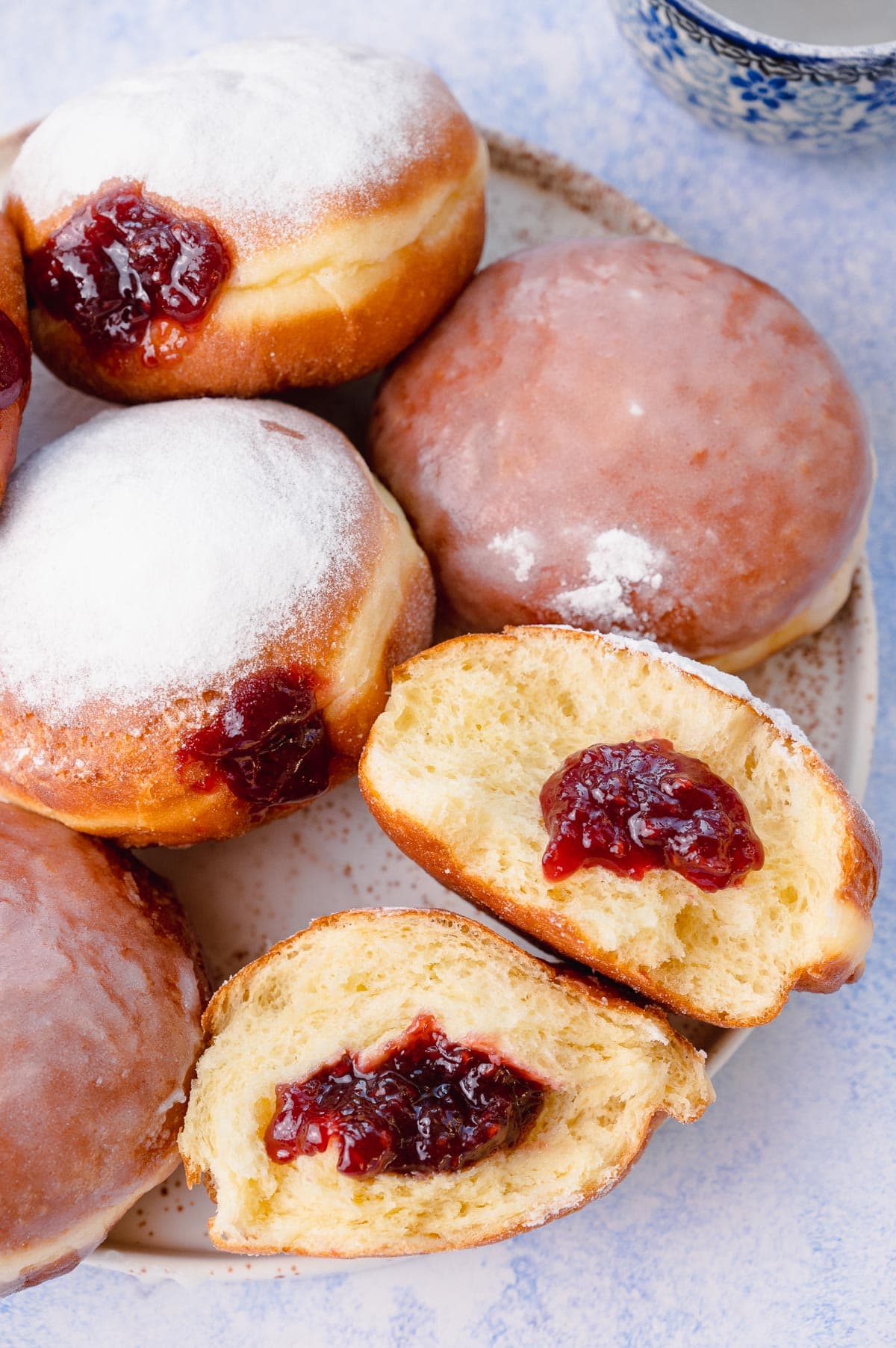 Polish doughnuts paczki filled with jam on a plate.