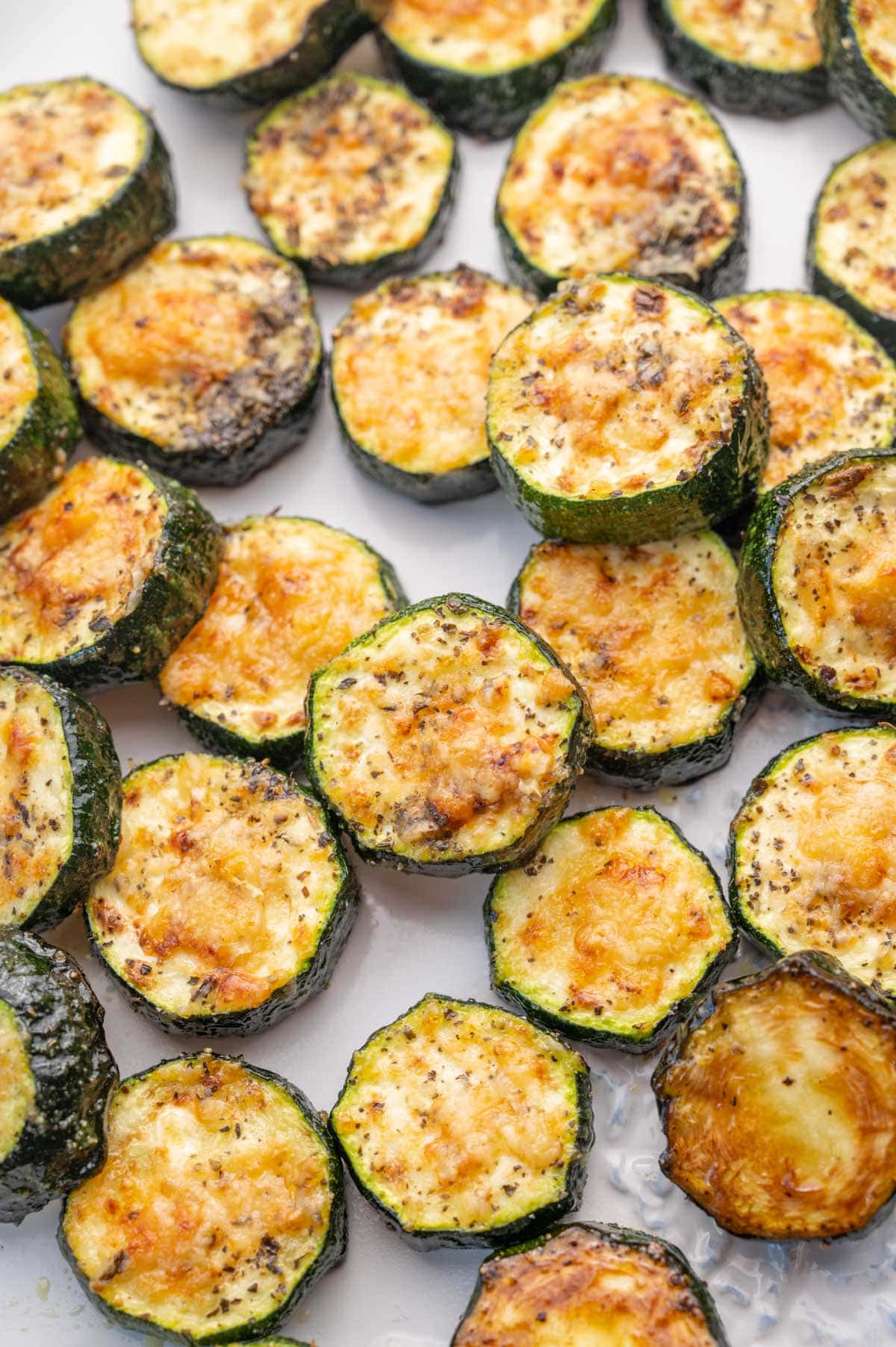 Baked parmesan zucchini on a white plate.