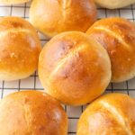 Brötchen bread rolls on a black cooling rack.