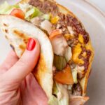 A Big Mac taco is being hold in a hand.